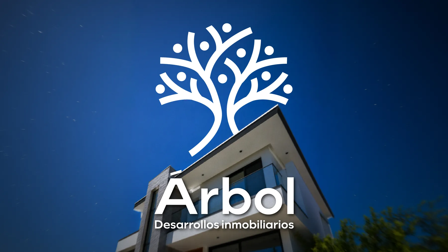 Logo de Árbol sobre una fachada de noche